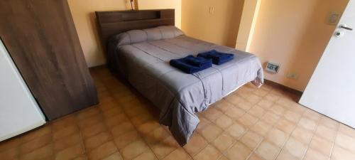 a bedroom with a bed with blue pillows on it at Departamento en Mendoza Capitál in Mendoza