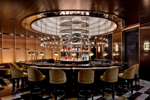 a bar with chairs and a large chandelier at Fontainebleau Las Vegas in Las Vegas