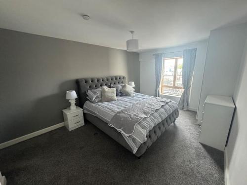 a bedroom with a large bed and a window at Luxury 2 bed fully equipped city centre apartment in Cork