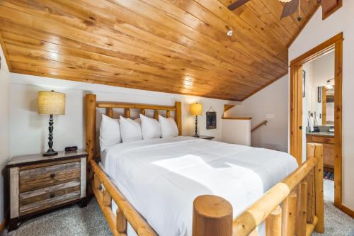 a bedroom with a large bed and a wooden ceiling at Bugle Pointe A01 by Estes Park Condos in Estes Park
