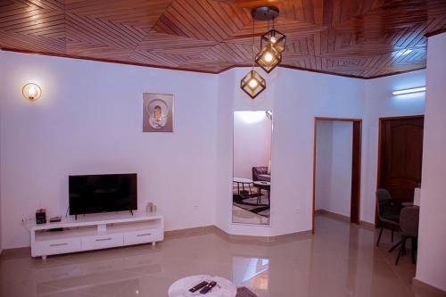 a living room with a flat screen tv on a wall at Ange meublés in Bassa