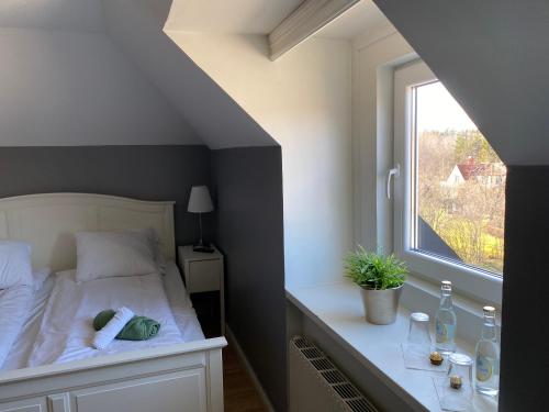 a bedroom with a white bed and a window at Häverödals hotell in Hallstavik