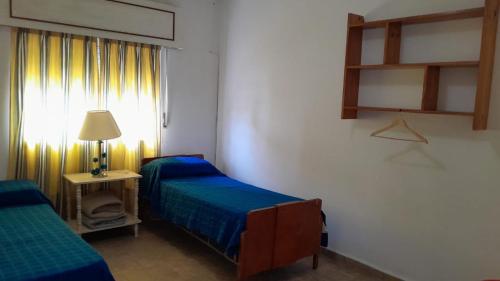a room with two beds and a lamp and a window at Milli in Gualeguaychú