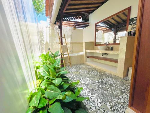 a bathroom with a plant in the corner of a room at Umah Teresna in Ubud