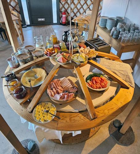 a wooden table with many plates of food on it at Náttúra Yurtel in Haukadalur