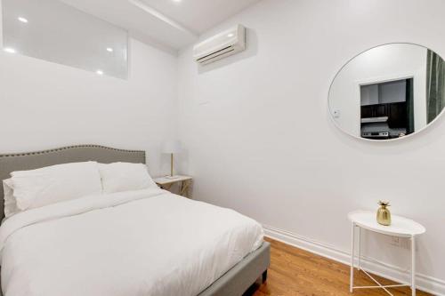 um quarto branco com uma cama e um espelho em M11 Beautiful Cozy 2BR wAC Perfect Location em Montreal