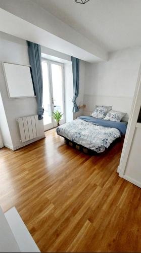 une chambre avec un lit et un parquet dans l'établissement Appartement avec terrasse - Orléans - Quai de Loire, à Orléans