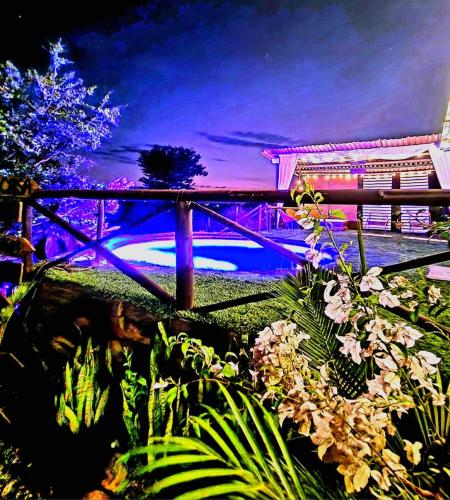 a garden with plants and a fence and a pool at Posada Turistica Rural y Glamping Altos del Dorado La Mesa in La Mesa