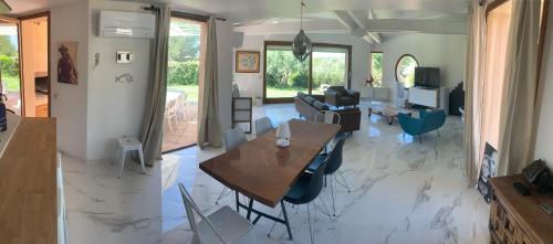 une cuisine et un salon avec une table et des chaises dans l'établissement Villa d’architecte avec piscine entre vignes et forêt, à Saint-Cyr-sur-Mer