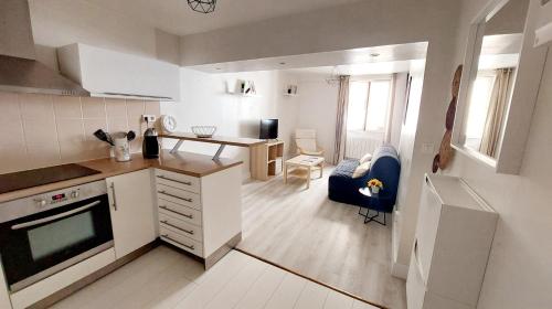 une cuisine et un salon avec un canapé et une table dans l'établissement Appartement avec terrasse - Orléans - Quai de Loire, à Orléans