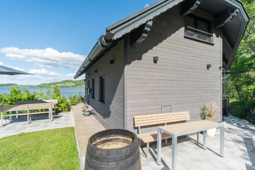 a building with a picnic table and a bench at Urlaub am See Seehaus Salzburg Mattsee Obertrum Seeham Salzburger Seenland in Obertrum am See