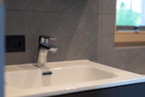 a sink with a faucet in a bathroom at Urlaub am See Seehaus Salzburg Mattsee Obertrum Seeham Salzburger Seenland in Obertrum am See