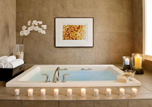 a bathroom with a bath tub with candles in it at Casa Munras Garden Hotel & Spa in Monterey