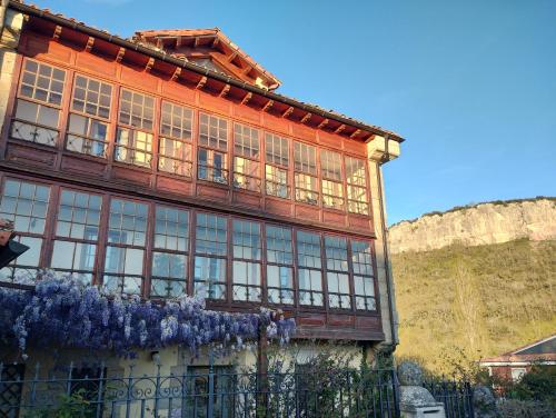 a building with windows and purple wreaths on it at HOTEL RURAL LA ENGAÑA in Pedrosa