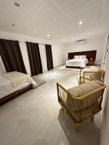 1 dormitorio grande con 2 camas y 1 silla en Villa Sunrise RD en Las Galeras