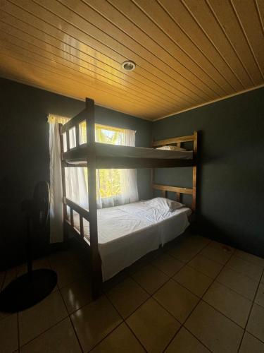 - une chambre avec des lits superposés et une fenêtre dans l'établissement Casa Ara Macao, à Paquera