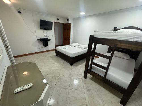 a room with two bunk beds and a television at HOTEL PLAZA REAL SUR in Cali
