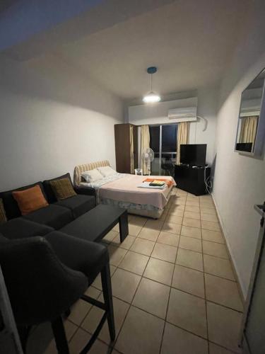 a living room with a bed and a couch at Studio apartment in Larnaca