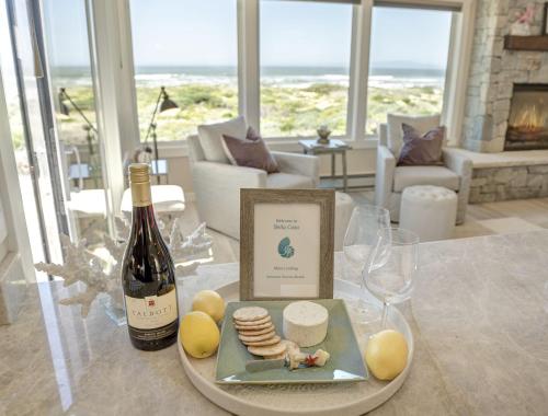 uma mesa com uma garrafa de vinho e um prato de queijo em 3930 Bella Casa condo em Moss Landing