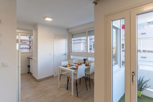 una cucina e una sala da pranzo con tavolo e sedie di Apartamento Torre Cervantes, moderno, luminoso, a 5 min de la Playa a Almería