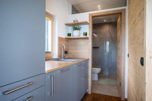 a small bathroom with a sink and a shower at Hideaway Kraftplatz Chalet am See Mattsee Obertrum Urlaub am See Salzburger Seenland in Obertrum am See