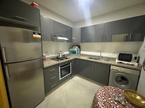 La cuisine est équipée d'un réfrigérateur en acier inoxydable et d'un lave-vaisselle. dans l'établissement APPARTEMENT FAMILIAL ELHOUDA, à Agadir