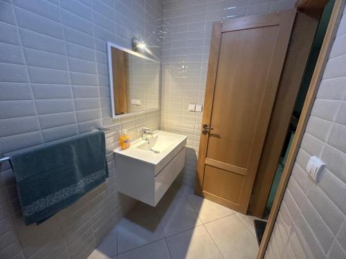 La salle de bains est pourvue d'un lavabo et d'un miroir. dans l'établissement APPARTEMENT FAMILIAL ELHOUDA, à Agadir