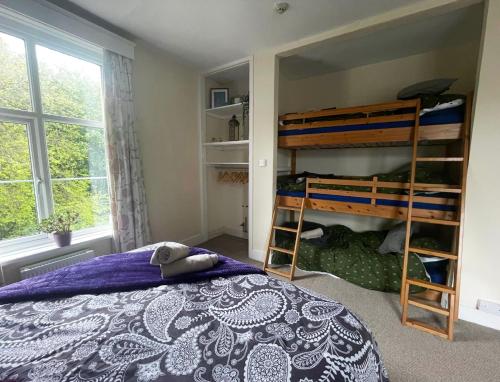 1 Schlafzimmer mit 2 Etagenbetten und einem Fenster in der Unterkunft Private 7 bed wing of former farmhouse, edge of Exmoor, sleeps 16 in East Anstey