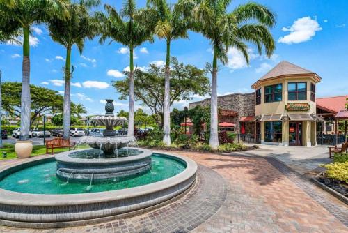 a fountain in the middle of a street with palm trees at Waikoloa Beach Villas L3 in Waikoloa