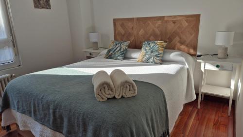a bedroom with a bed with towels on it at Urbanizacion los Delfines in Santander