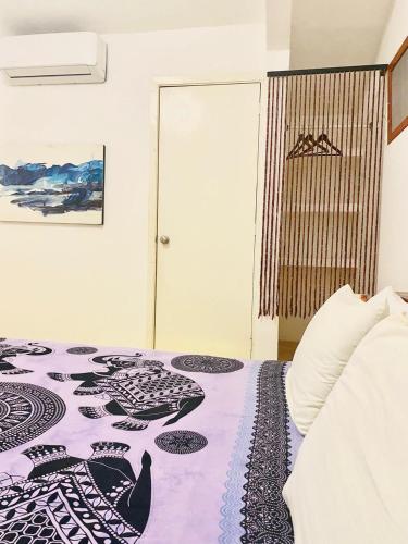a bedroom with a bed with a bird design on it at Casa de las Olas Surf & Beach Club in Acapulco