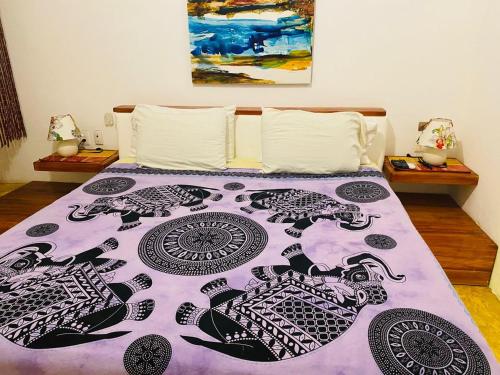 a bed with a purple comforter with animals on it at Casa de las Olas Surf & Beach Club in Acapulco