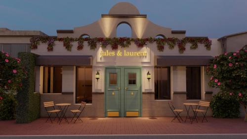 un edificio con una puerta azul y sillas en la parte delantera en Jules & Laurent Hotel Contemporaneo, en Ensenada
