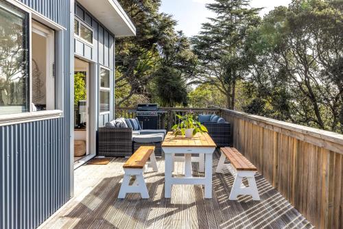 a patio with a table and benches on a deck at Palm Beach Haven in Palm Beach