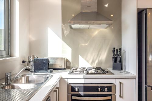 a kitchen with a stove and a sink at Palm Beach Haven in Palm Beach