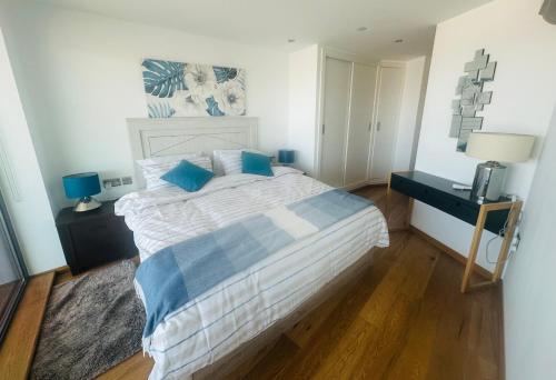 1 dormitorio con 1 cama grande con almohadas azules en Luxury Apartment with Swimming pools, Spa and stunning views, en Gibraltar