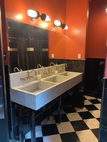 a bathroom with two sinks and a large mirror at The Nolita Express Hostel in New York