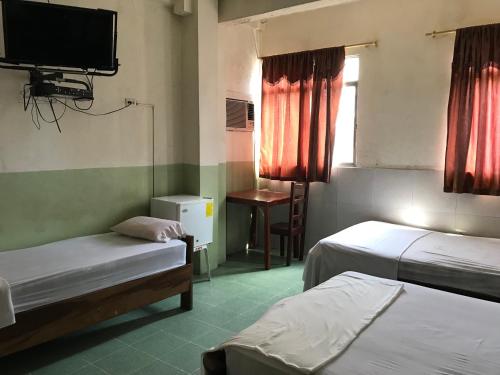Cette chambre comprend 2 lits et une télévision murale. dans l'établissement Hotel Luque, à Guayaquil