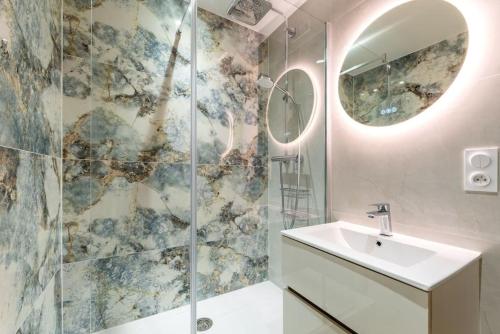 une salle de bain avec un lavabo et une douche avec un miroir dans l'établissement Envole - moi, à Mont-Saint-Aignan