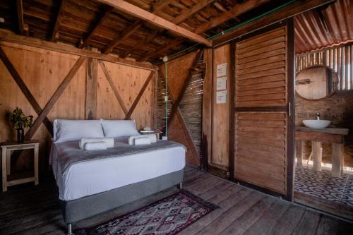 a bedroom with a bed and a sink in a room at Watu Kite House in Mayapo