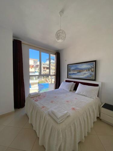 a bedroom with a large bed with a large window at Alvi Apartment 1 in Sarandë