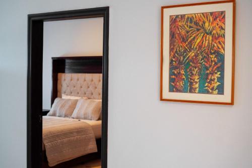 a mirror on a wall next to a bed at Residencial Del Golf in La Lima