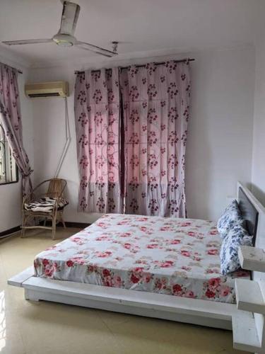 Bett in einem Schlafzimmer mit rosa Vorhängen in der Unterkunft Home sweet home in Daressalam