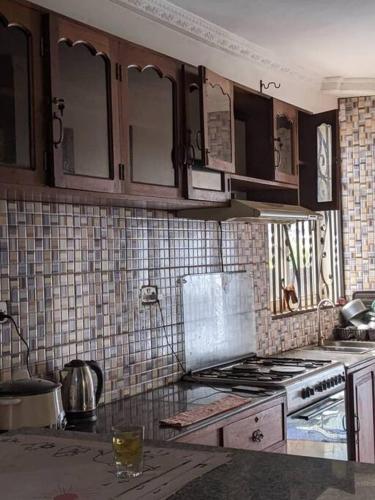 a kitchen with wooden cabinets and a stove top oven at Home sweet home in Dar es Salaam
