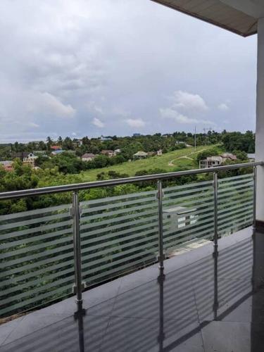 einen Balkon mit Blick auf ein grünes Feld in der Unterkunft Home sweet home in Daressalam