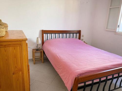 a bedroom with a bed with a pink blanket at Duplex Statia vue sur Port in El Jadida