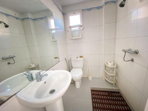 a white bathroom with a sink and a toilet at Duplex Statia vue sur Port in El Jadida