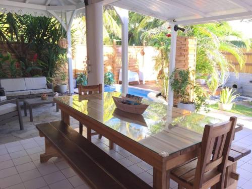 une table et des bancs en bois sur une terrasse dans l'établissement Le Corail Rouge, au Diamant