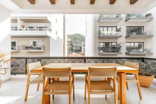 a dining room with a wooden table and chairs at Urban by Pardela in Puerto Vallarta