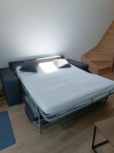 - un lit dans une pièce à côté d'un escalier dans l'établissement Le petit duplex des barres, à La Boissière-de-Montaigu